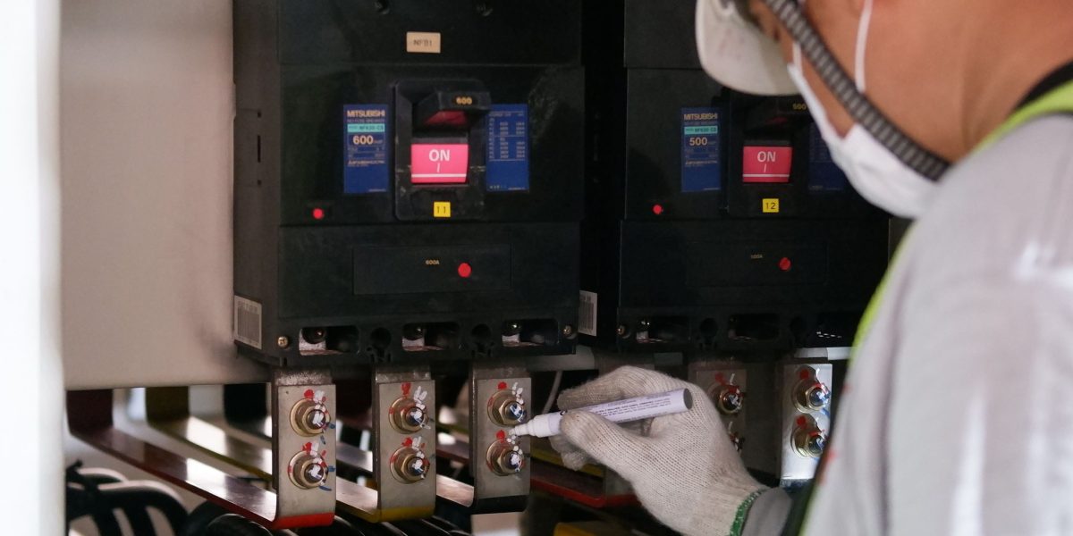 A focused technician uses advanced tools to perform precise quality control on a production line.