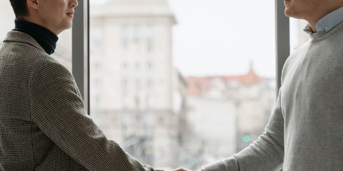Two professionals shaking hands, symbolizing successful networking or the outcome of a well-crafted job application.