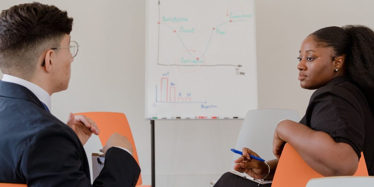 Two professionals brainstorm ideas on a whiteboard, symbolizing strategic partnerships and joint development efforts.