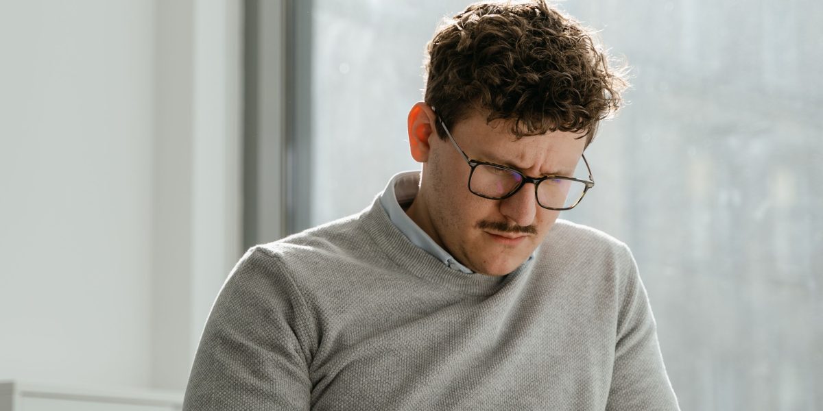 A person contemplates the authenticity of written content, questioning its origin.